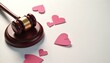 © Pete - Judges gavel rests near scattered pink paper hearts. Symbolizes legal decisions in relationships marriage divorce or domestic matters. Justice and love connect.