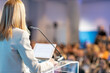 © Mihajlo Maricic - Female public speaker at business conference, corporate presentation, workshop, coaching training, news conference, company meeting, public or political event. Public speaking concept.