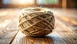 © SitiNabilah - A tightly wound ball of natural twine resting on a weathered wooden surface, showcasing rustic texture and potential for crafting projects.