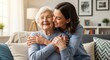 © An - A young woman embraces her smiling elderly grandmother. They are both wearing light blue sweaters and sharing a warm, affectionate hug.