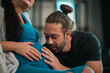 © chokniti - Father's Day Concept, pregnant woman and man touching belly in intimate home moment