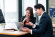 © Crystal - Two business professionals collaborating on a laptop, discussing strategy and reviewing charts in a modern office meeting