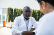 © Davor - Doctor consulting with colleague outdoors at hospital