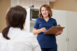 © Maria - doctor is talking with young female patient and making notes while standing near