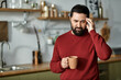 © LIGHTFIELD STUDIOS - Handsome man in cozy kitchen holding cup and reflecting on a thoughtful moment at home