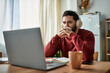 © LIGHTFIELD STUDIOS - Focused adult man at home engages in deep thought while working on his laptop