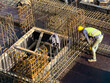 © A I E/Stocksy - Construction Worker with Helmet Binding Steel Rebars at Site