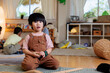 © Jovo Jovanovic/Stocksy - Young boy in overalls plays in a bright playroom.