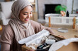 © Jovo Jovanovic/Stocksy - Woman smiles while opening a box of beauty products.