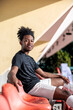 © Jovo Jovanovic/Stocksy - Happy athlete sits in sunny stadium seat