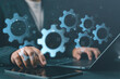 © Nirusmee - Automation system development with gear icons and workflow technology, featuring programmer coding on laptop, representing application development, process automation, and software engineering.