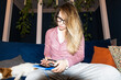 © Asya Molochkova/Stocksy - Thoughtful Woman in Glasses Writing with Phone and Notebook