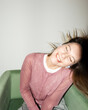 © Asya Molochkova/Stocksy - Woman in Headphones Dancing in Chair with Flash