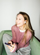 © Asya Molochkova/Stocksy - Smiling Woman Using Smartphone at Home