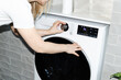 © Asya Molochkova/Stocksy - Woman Setting Washing Machine at Home Laundry Room