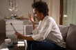 © Niyaz Tavkaev/Stocksy - Happy black female freelancer making online call on sofa