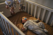 © Daniel Gonzalez/Stocksy - Baby lying in crib looking at mobile