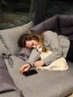 © Asya Molochkova/Stocksy - Woman Sleeping on Sofa with Small Dog at Home