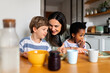© Santi Nuñez/Stocksy - Happy mother teaching diverse children cooking pancakes
