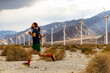 © Raymond Forbes LLC/Stocksy - Athlete running desert Wind turbine farm