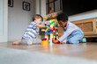 © Santi Nuñez/Stocksy - Diverse children playing colorful marble run toy