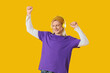 © Pixel-Shot - Young blonde man in hat with headphones dancing on yellow background