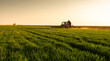 © Dusan Kostic - Farmer in tractor spraying crops at sunset