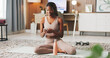 © peopleimages.com - Happy, fitness and phone with black woman in home for communication, health app and break. Social media, yoga pose search and connection with person and mobile in living room of house for wellness