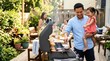 © mashimara - Father and daughter enjoy a backyard barbecue with family on a sunny day