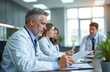 © Viktor - Medical team discusses patient chart in hospital office. Doctors review data at desk. Staff collaborates on healthcare treatment. Teamwork in clinic advances medicine.