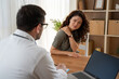 © Nenad - Female patient with shoulder pain talking to doctor in medical office