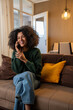 © Nenad - Beautiful african woman talking on phone in cozy living room at home