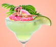 © New Africa - Beautiful woman with swim ring in glass of cocktail against pink background