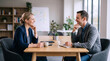 © Karen - Two Business Professionals Smiling During One-on-One Meeting at Office Table with Coffee