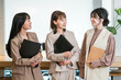 © buritora - Smiling businesswomen (working women, working mothers) lined up in an office.