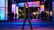 © DSGNCO - Young adult man standing in colorful urban night scene.