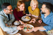 © djile - Friends enjoying brunch and sharing food at restaurant table