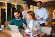 © djile - Business colleagues collaborating on laptop in modern cafe
