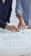 © rogerphoto - Professional team collaborating, reviewing financial graphs, calculating metrics, discussing performance insights and strategic planning in modern corporate workspace. Business people concept