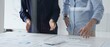© rogerphoto - Business professionals analyzing financial charts, gesturing over spreadsheets during collaborative meeting in contemporary workspace, discussing data driven insights