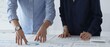 © rogerphoto - Business colleagues are examining financial data, pointing at charts and graphs spread out on a table during a collaborative analysis session in a modern office.