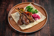 © zukamilov - Grilled lamb chops with vegetables and flatbread on plate
