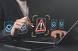 © Nirusmee - Problematic document and rejected file with error notification on approval system, featuring businessman using laptop to submit documents for compliance verification and review.