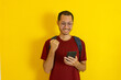 © Tito Rollis - Young man with eye glass with backpack clenched fist with smile on isolated yellow
