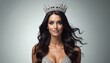 © miss irine - Woman wears sparkly crown and dress. She has long dark wavy hair and is smiling. Beauty pageant winner looks elegant in studio setting. Achieving a dream.