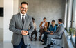 © NDABCREATIVITY - Multicultural professional businesspeople working together on research plan in boardroom.