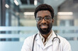 © Liubomir - Male professional doctor looking at camera and smiling, wearing a white lab coat and stethoscope, posing against a modern clinic background, representing healthcare expertise and patient care