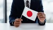 © Tata - Businessman holds Japanese flag at desk