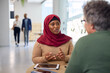 © Rido - Businesswoman in hijab making financial consultation with client