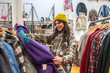 © unai - Young woman finding vintage clothes in a thrift store